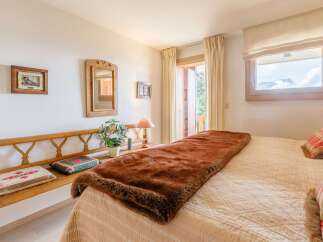 Cozy bedroom with a rustic wooden bench and a plush brown throw blanket.