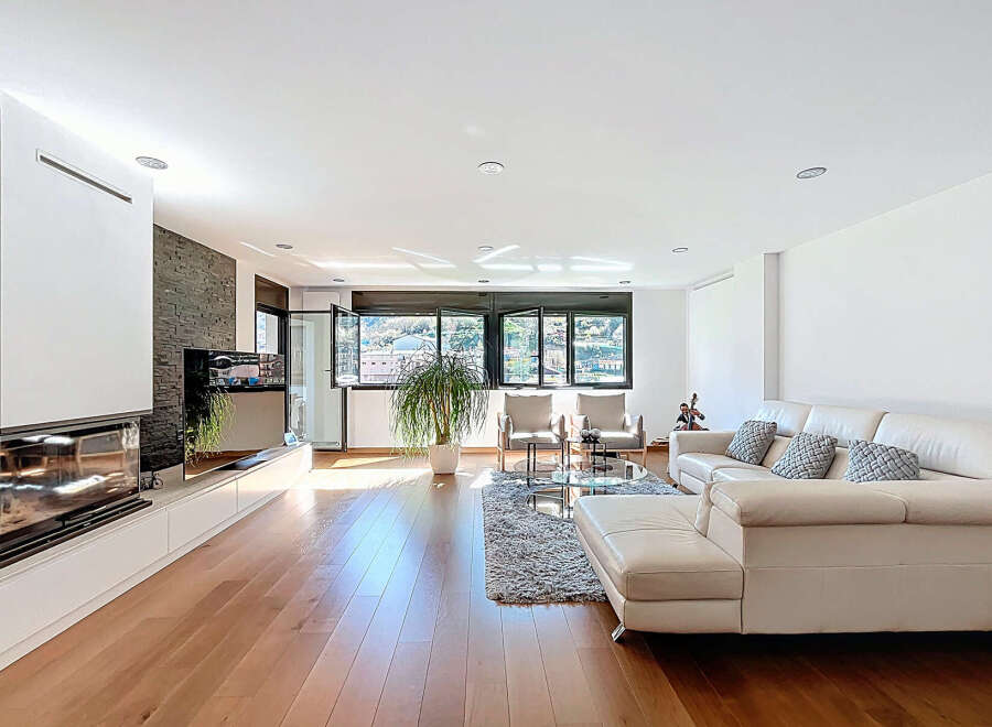Stunning living room with hardwood floors, a modern fireplace, and floor-to-ceiling windows offering breathtaking views.