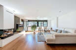 Stunning living room with hardwood floors, a modern fireplace, and floor-to-ceiling windows offering breathtaking views.