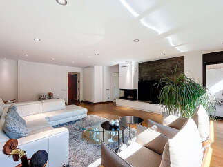 Stunning living room with a modern fireplace and large windows, offering ample natural light.