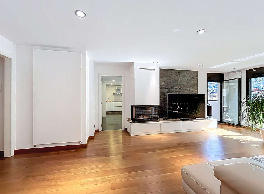 Stunning modern living space featuring hardwood floors, a sleek fireplace, and floor-to-ceiling windows offering abundant natural light.