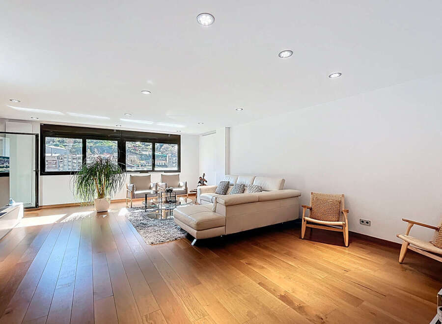 Stunning living room with hardwood floors and large windows offering scenic views.