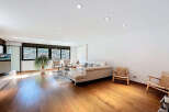 Stunning living room with hardwood floors and large windows offering scenic views.