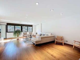 Stunning living room with hardwood floors and large windows offering scenic views.