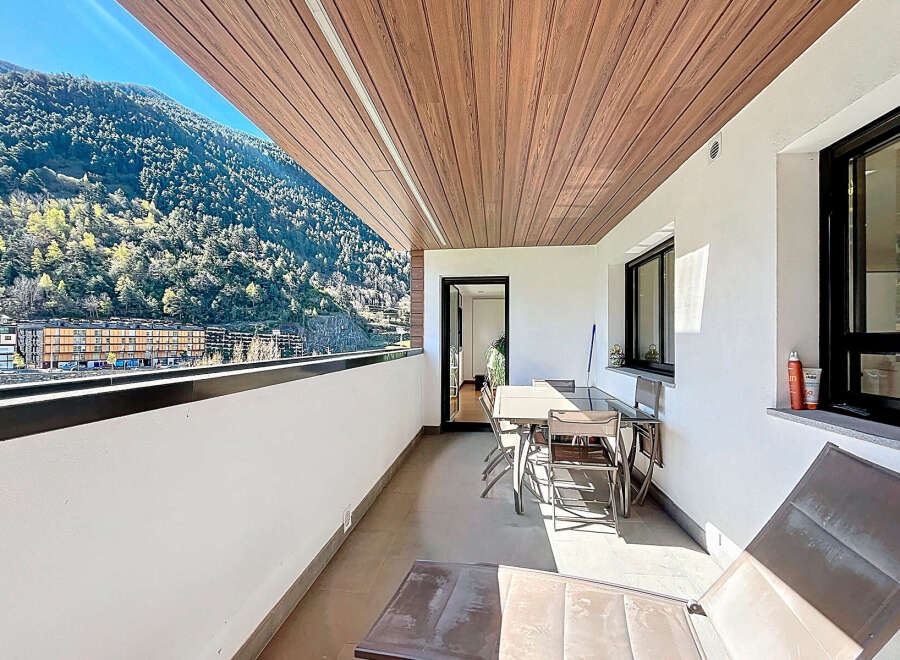 This stunning balcony boasts breathtaking mountain views and a spacious layout perfect for outdoor dining and relaxation.