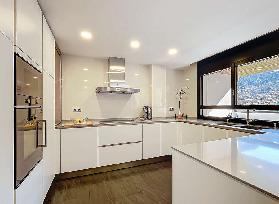 Modern kitchen with sleek white cabinets and integrated appliances.