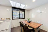 Modern kitchen with sleek countertops and a wooden dining table.