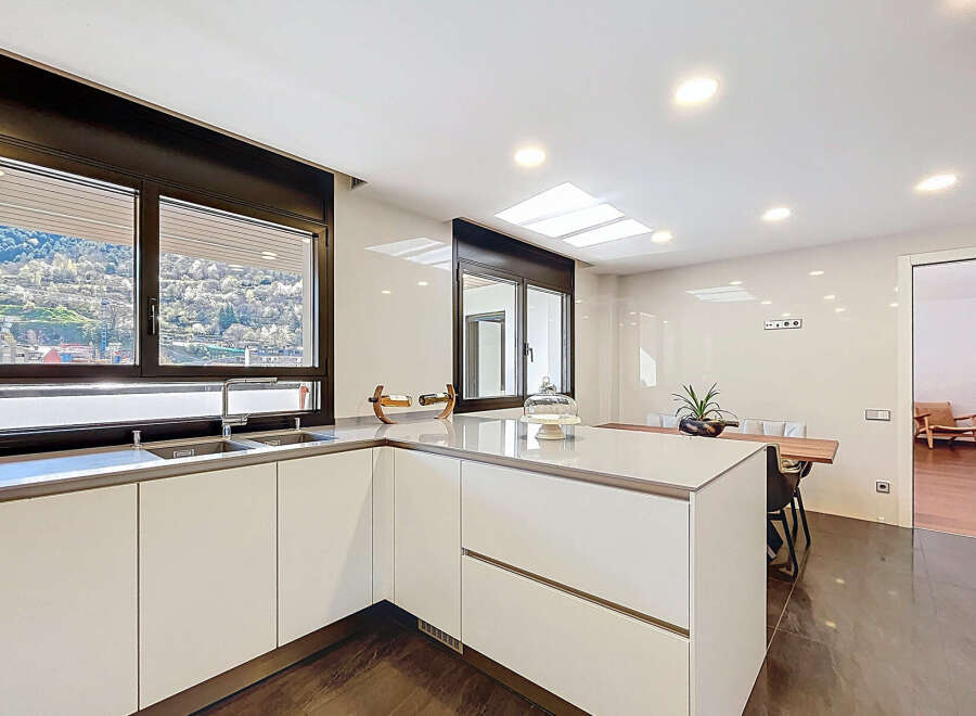 Modern kitchen with sleek white cabinets and stunning mountain views.