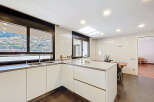 Modern kitchen with sleek white cabinets and stunning mountain views.