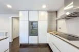 Modern kitchen with sleek white cabinets and integrated appliances.