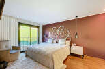 Luxurious bedroom with a king-size bed and an ornate headboard.