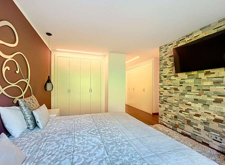 Luxurious bedroom with custom headboard and built-in closets.