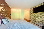 Luxurious bedroom with custom headboard and built-in closets.