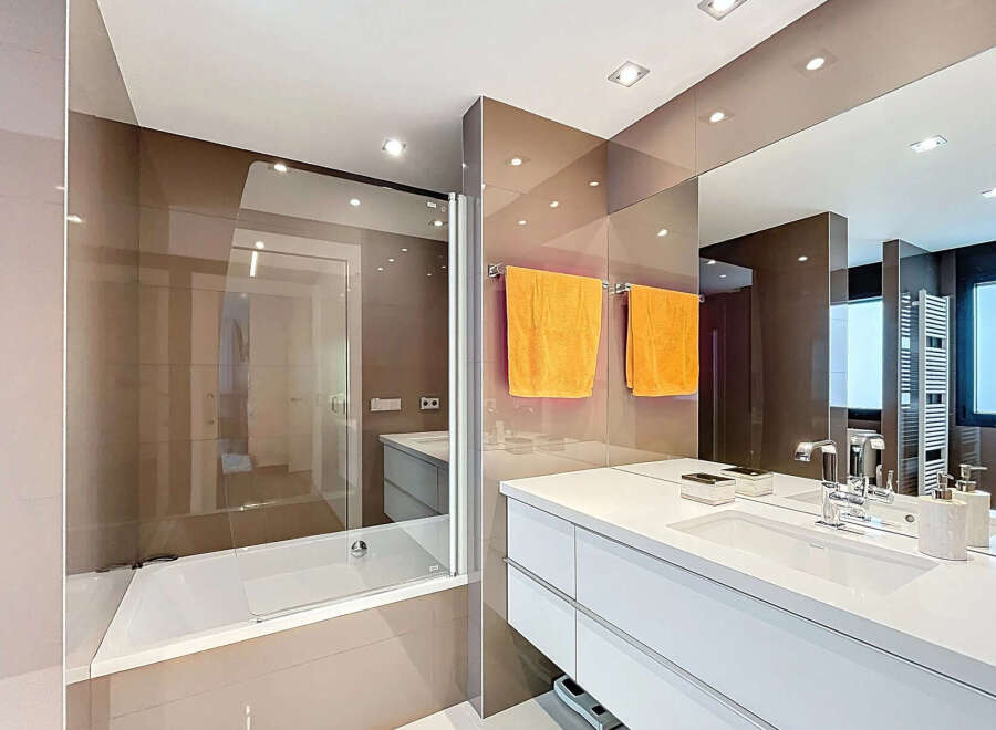 Modern bathroom with a built-in bathtub and a sleek white vanity.