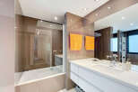 Modern bathroom with a built-in bathtub and a sleek white vanity.