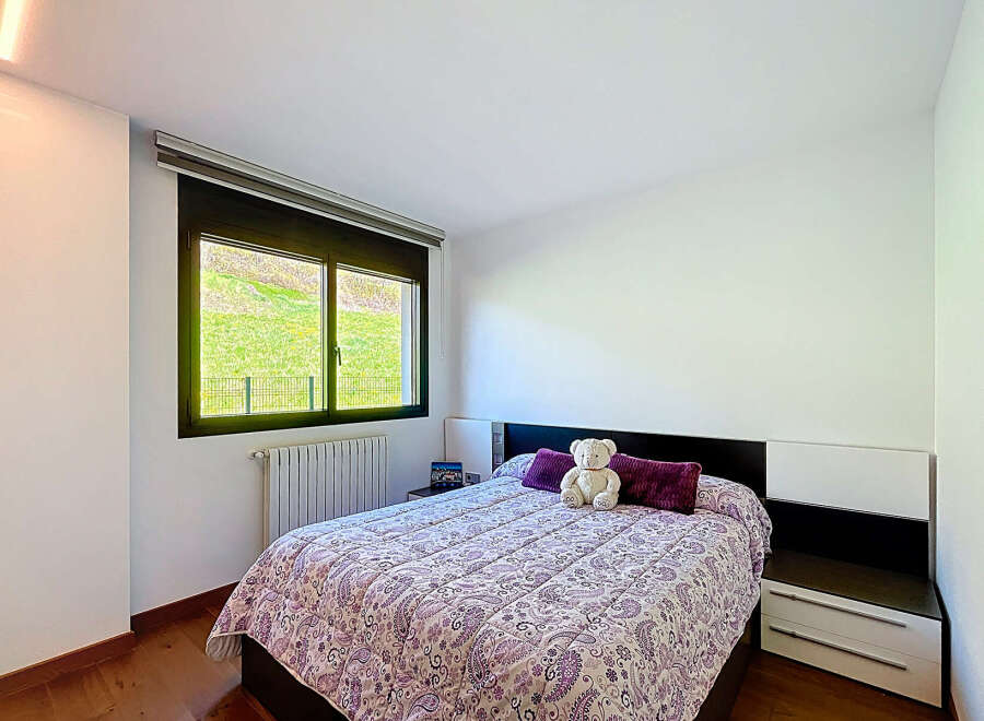 Cozy bedroom with a double bed, featuring a beautiful patterned duvet and plush pillows.