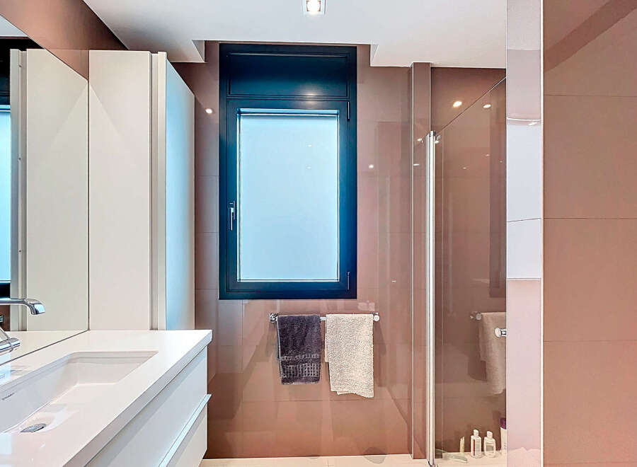 Modern bathroom with sleek white vanity and integrated sink.