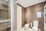 Modern bathroom with a walk-in shower, toilet, and bidet.