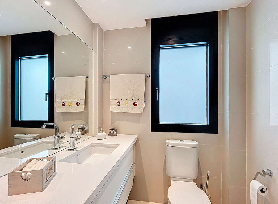 Modern bathroom with white countertops and a sleek design.