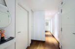 This stunning hallway boasts sleek, modern white doors and hardwood floors, creating an elegant and sophisticated atmosphere.