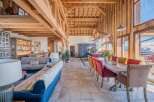 This stunning chalet boasts a spacious open-plan living area with exposed wooden beams and a cozy fireplace, perfect for relaxing after a day on the slopes.