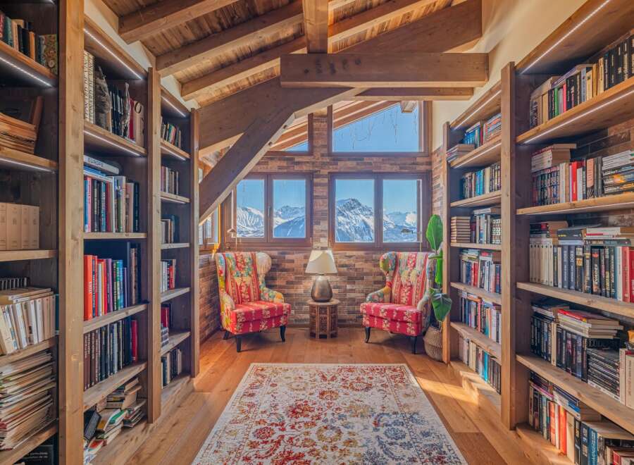 Cozy mountain chalet library with stunning views.