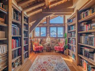 Cozy mountain chalet library with stunning views.