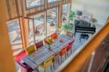 This stunning home boasts a spacious dining area with a rustic wooden table and colorful chairs, perfect for entertaining guests.