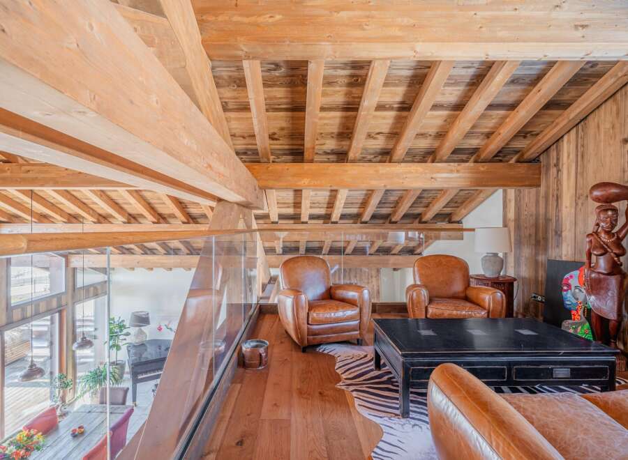 This stunning chalet boasts a breathtaking wooden interior with exposed beams and a spacious open-plan living area.