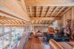 This stunning chalet boasts a breathtaking wooden interior with exposed beams and a spacious open-plan living area.