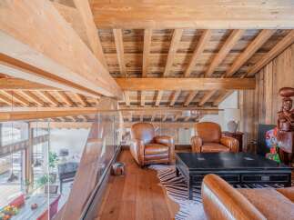 This stunning chalet boasts a breathtaking wooden interior with exposed beams and a spacious open-plan living area.