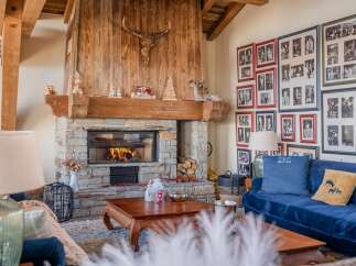 Cozy up by the fireplace in this stunning chalet, complete with a rustic stone hearth and wooden mantel.