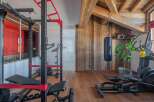 This stunning home gym boasts a full set of professional-grade equipment, including a squat rack, weight bench, and elliptical machine.
