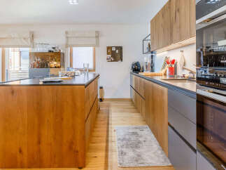 This stunning kitchen boasts a modern design with sleek wooden cabinetry and a spacious island.