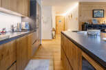 This stunning kitchen boasts a modern design with sleek countertops and warm wooden cabinetry.