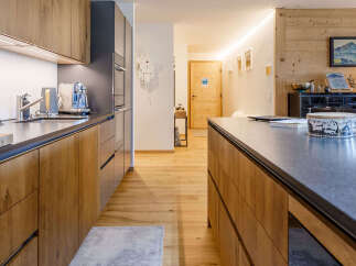 This stunning kitchen boasts a modern design with sleek countertops and warm wooden cabinetry.