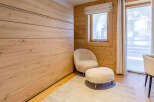 This cozy bedroom features a stunning wooden wall and a comfortable seating area.