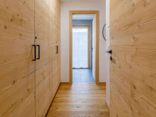 Explore the warmth of this inviting hallway, featuring stunning wooden paneling that extends throughout.