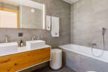 This modern bathroom features a sleek design with a double vanity and a luxurious bathtub.