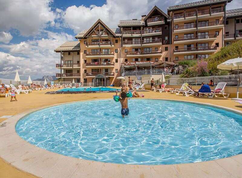 This stunning resort boasts a beautiful outdoor pool area perfect for families, featuring both a large pool and a separate paddling pool for younger children.