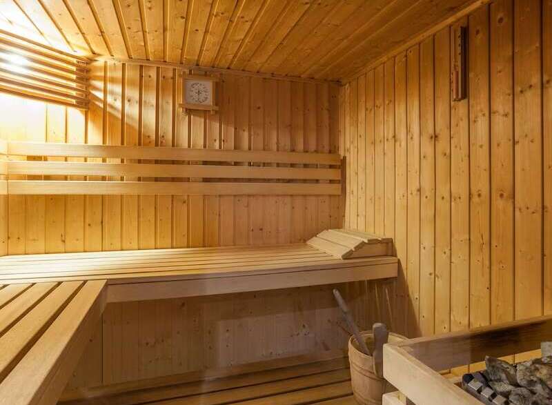 Relax and rejuvenate in this exquisite sauna, featuring a calming wooden interior and ample seating.