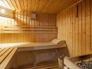 Relax and rejuvenate in this exquisite sauna, featuring a calming wooden interior and ample seating.