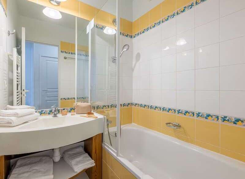 This charming bathroom boasts a clean and modern design with a bathtub and shower combination.