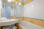 This charming bathroom boasts a clean and modern design with a bathtub and shower combination.
