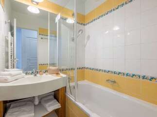 This charming bathroom boasts a clean and modern design with a bathtub and shower combination.