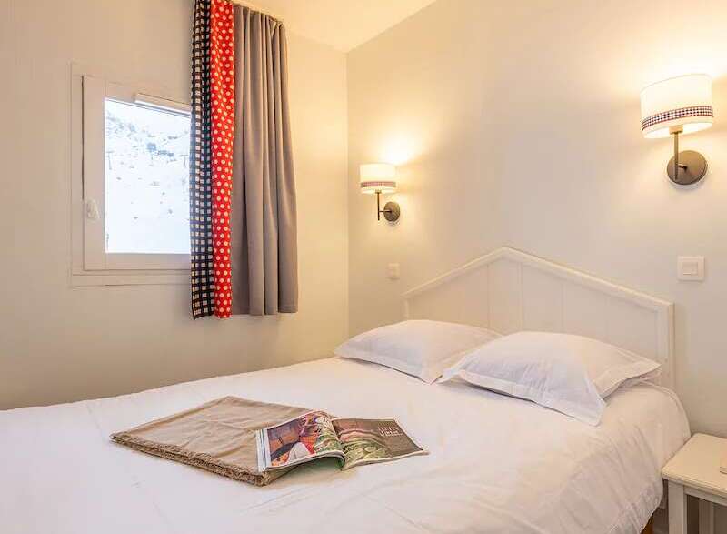 Cozy bedroom with a comfortable double bed, crisp white linens, and soft lighting.