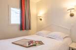 Cozy bedroom with a comfortable double bed, crisp white linens, and soft lighting.