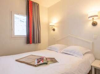 Cozy bedroom with a comfortable double bed, crisp white linens, and soft lighting.