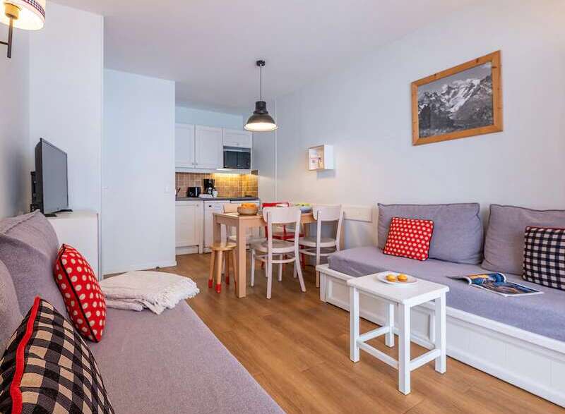 Cozy apartment featuring a comfortable sofa bed, fully equipped kitchenette, and dining area.