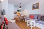 Cozy apartment featuring a comfortable sofa bed, fully equipped kitchenette, and dining area.